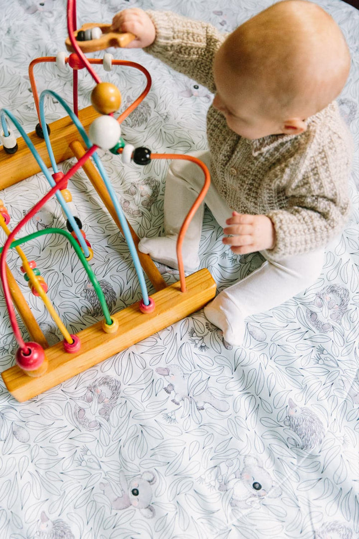 Baby playing on a Cuddly Faces Bay Play Mat