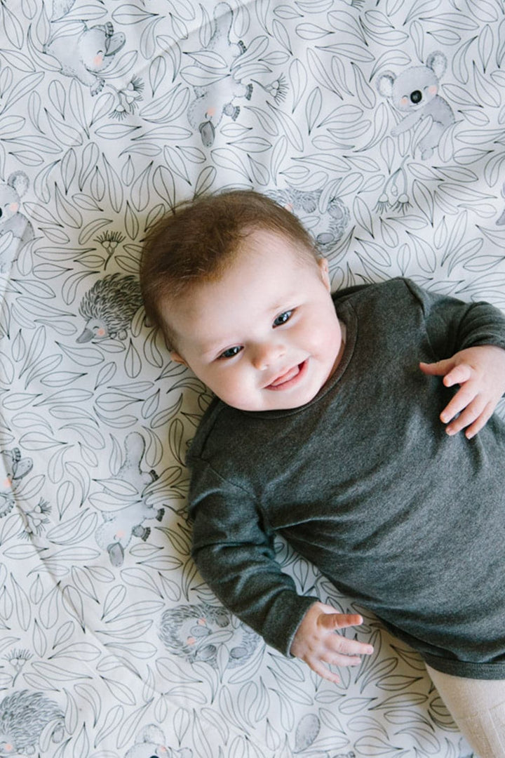 Baby laying on a Cuddly Faces play mat